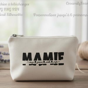 Peut inclure: Une pochette zippée en toile crème avec le mot "MAMIE" imprimé en lettres noires grasses. En dessous, les noms "ensa jeanne noah mya" sont imprimés en plus petit. Le texte "Fichier à télécharger SVG PNG PDF Cricut Silhouette" et "Personnaliser jusqu'à 6 prénoms".