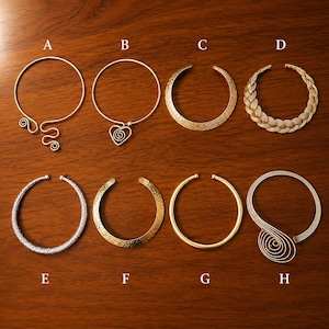 Könnte beinhalten: Eine Sammlung von acht Metallhalsreifen, beschriftet von A bis H. Die Designs umfassen Drahtspiralen, Herzformen, geflochtene Texturen, gehämmerte Oberflächen und glatte Bänder in Gold- und Silbertönen, angeordnet in zwei Reihen auf Holz.