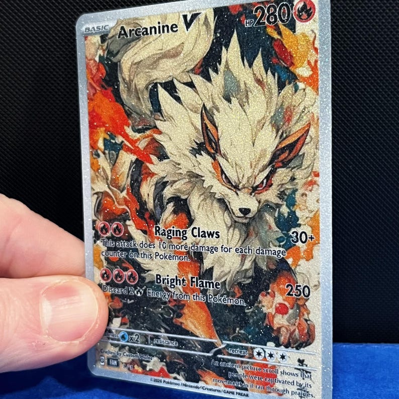 Puede incluir: Carta Pok&eacute;mon Arcanine V hologr&aacute;fica. La carta presenta una ilustraci&oacute;n detallada de Arcanine con pelaje naranja y blanco. El texto de la carta incluye los ataques "Raging Claws" y "Bright Flame", junto con los valores de HP y da&ntilde;o.