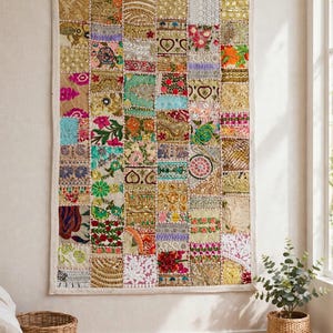 May include: A rectangular wall hanging featuring a patchwork design composed of numerous small, square fabric panels. Each panel displays distinct embroidery, metallic thread work, sequins, and floral patterns in a vibrant array of colours.