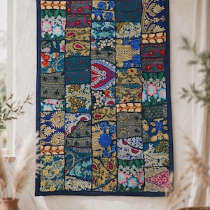 May include: A rectangular wall hanging featuring a patchwork design of various fabric squares. The textile displays a vibrant array of colors including deep blue, gold, red, and green, with intricate embroidery, sequins, and floral patterns.