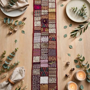 May include: A rectangular table runner featuring a patchwork design composed of numerous small, square fabric panels. The runner displays a variety of intricate textures, metallic gold embroidery, and vibrant colors including deep red, purple, and white.