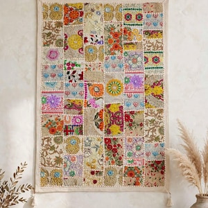 May include: A rectangular wall hanging featuring a patchwork design composed of numerous small, embroidered fabric squares. The textile displays a vibrant array of colors including red, yellow, orange, blue, and green, with intricate floral and geometric patterns.