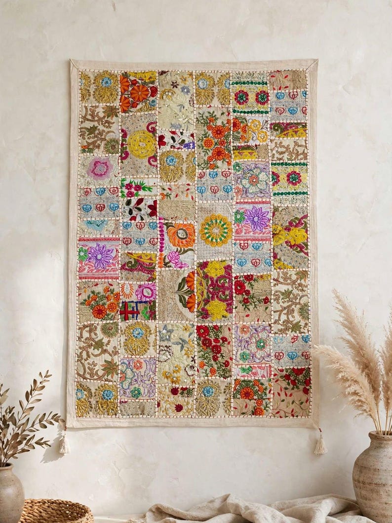 May include: A rectangular wall hanging featuring a patchwork design composed of numerous small, embroidered fabric squares. The textile displays a vibrant array of colors including red, yellow, orange, blue, and green, with intricate floral and geometric patterns.