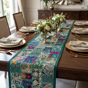 Peut inclure: Un long chemin de table rectangulaire compos&eacute; d'un assemblage de carr&eacute;s de tissu brod&eacute;s dans des tons de bleu sarcelle, vert, rose et dor&eacute;. Le chemin de table pr&eacute;sente une bordure vert fonc&eacute; unie et des motifs floraux et g&eacute;om&eacute;triques complexes.