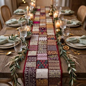 May include: A rectangular table runner featuring a patchwork design of various embroidered fabric squares in shades of deep red, gold, white, and purple, accented with metallic thread, sequins, and intricate floral and geometric patterns.