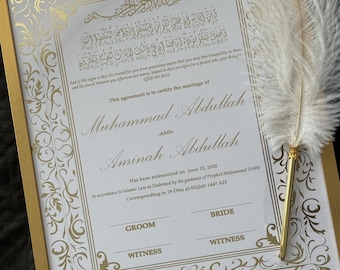 May include: A framed marriage certificate with gold accents and ornate calligraphy. The document, in English and Arabic, certifies the marriage of Muhammad Abdullah and Aminah Abdullah. A white feather quill rests on the frame.