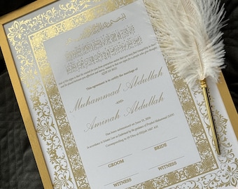 May include: A framed marriage certificate with gold accents and ornate detailing. The certificate is white with gold text and a decorative border. A large white feather quill with a gold pen holder rests on the frame.