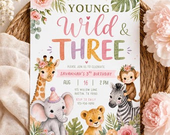 Op de afbeelding: Een rechthoekige verjaardagsuitnodigingskaart met de tekst YOUNG Wild & THREE. Het ontwerp bevat aquarelillustraties van een giraf, olifant, aap, zebra en leeuwenwelp, omringd door roze bloemen en groene tropische bladeren.