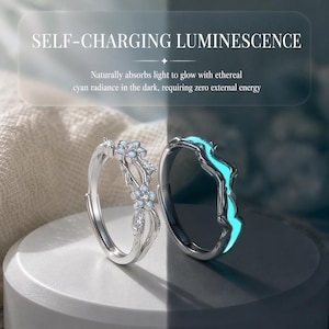 May include: Two silver-toned rings. The left ring features a floral design with small white petals and clear stones. The right ring displays a glowing cyan wave pattern. Text reads: SELF-CHARGING LUMINESCENCE. Naturally absorbs light to glow.