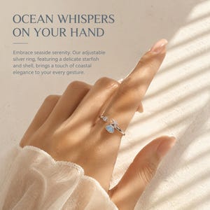 May include: An adjustable silver ring featuring a small starfish and a light blue shell charm. The text on the image reads: OCEAN WHISPERS ON YOUR HAND. Embrace seaside serenity. Our adjustable silver ring, featuring a delicate starfish and shell, brings a touch of coastal elegance to your every gesture.