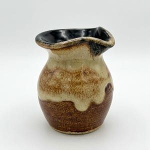 May include: A white ceramic mug with a black handle and the text "But First, Coffee" in a black, bold font. The mug is sitting on a wooden surface.