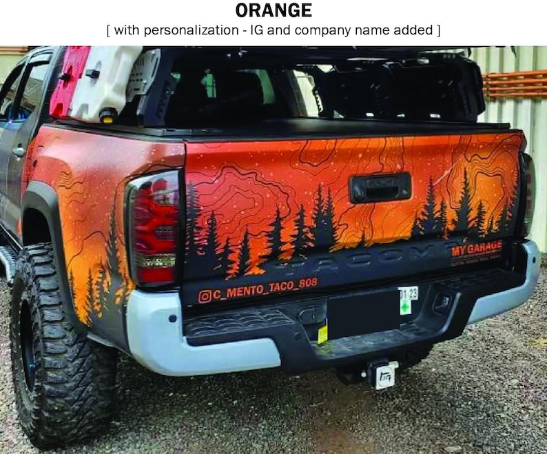 Puede incluir: Parte trasera de una camioneta con un dise&ntilde;o de monta&ntilde;a y bosque en naranja y negro. El dise&ntilde;o incluye el texto "MY GARAGE" y un identificador de Instagram. La camioneta tiene neum&aacute;ticos grandes y un parachoques negro.