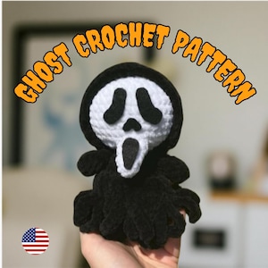 May include: A handmade black and white crochet ghost doll, featuring the iconic Scream mask design. The doll has a black hood and body, with a white face and black eye and mouth details. The text "GHOST CROCHET PATTERN" is arched above the doll.