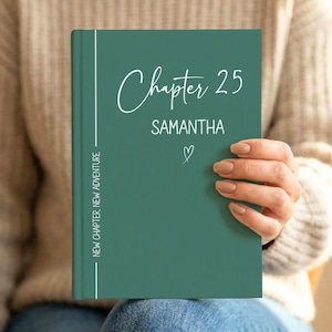 Può includere: Un libro con copertina rigida verde scuro con testo bianco che recita Chapter 25, SAMANTHA e NEW CHAPTER, NEW ADVENTURE, con una piccola icona a forma di cuore bianco. Il libro presenta una linea verticale bianca sul lato sinistro.