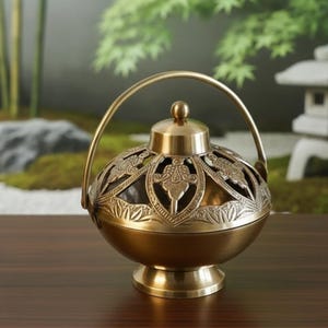 Può includere: Un bruciatore di incenso color oro con un design traforato decorativo. Il bruciatore ha un corpo rotondo, un coperchio con un piccolo pomello e un manico. La base è un piccolo piedistallo rotondo. Lo sfondo presenta un giardino.