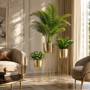 Puede incluir: Tres soportes de plantas de metal dorado de diferentes alturas, cada uno con una planta verde diferente. Las macetas doradas texturizadas se asientan sobre soportes dorados verticales y delgados. Los soportes están en un espacio habitable moderno y bien iluminado.