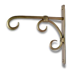 May include: A gold-coloured metal hanging bracket with a curved arm and decorative scrollwork. The bracket has a vertical mounting plate with two screw holes. The design is ornate and suitable for hanging plants or other decorative items.