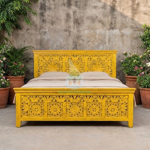Può includere: Un letto in legno giallo con intagli floreali intricati sulla testiera e sulla pediera. Il letto è dipinto di giallo brillante e ha un design semplice ed elegante. Il letto è di dimensioni queen, largo circa 152 cm.