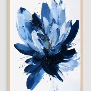 May include: Abstract floral painting in a wooden frame. The artwork features a large blue flower with varying shades of blue and white brushstrokes. Gold flecks add detail. The background is white.