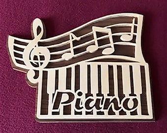 May include: A wooden wall decor with a piano keyboard design. The keyboard is made of brown wood and has white keys. The word "Piano" is written in white letters on the keyboard. There are musical notes and a treble clef on the top of the keyboard.