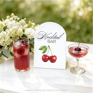 May include: A white sign with the words "Mocktail BAR" in elegant script, accompanied by a pair of red cherry illustrations. A tall glass and a coupe glass with cherry cocktails are on a white surface, with a bouquet of white flowers in the background.
