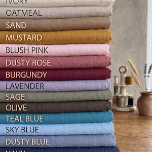 Może przedstawiać: Stos złożonych tkanin w różnych kolorach z tekstem: Pure White, Ivory, Oatmeal, Sand, Mustard, Blush Pink, Dusty Rose, Burgundy, Lavender, Sage, Olive, Teal Blue, Sky Blue, Dusty Blue, Navy oraz Black.