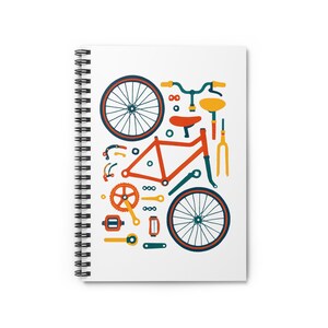 May include: Spiral-bound notebook featuring a colorful illustration of bicycle parts. The design includes a red frame, blue and orange wheels, and various components in orange, yellow, and blue. The notebook has a white cover and a black spiral binding.