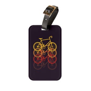 May include: A rectangular luggage tag with a black leather strap and gold buckle. The tag features a retro design of bicycles in shades of yellow, orange, and red on a dark purple background.