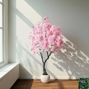 May include: An artificial cherry blossom tree with pink flowers. The tree has a dark trunk and branches, and is potted in a white, textured ceramic pot. The tree is in a room with a window and wooden floorboards. The pot is approximately 30 cm in diameter.