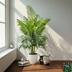 Puede incluir: Una gran palmera artificial verde vibrante en una maceta blanca. La planta se coloca en un suelo de madera junto a una ventana. Una cesta negra con una manta beige está cerca. La escena está iluminada por la luz natural.