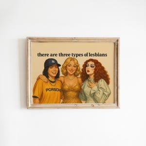May include: Framed print featuring a vintage-style illustration of three women. The text "there are three types of lesbians" is at the top. The women are in various outfits, including a baseball cap and a gold dress.
