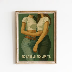 May include: A framed art print featuring two figures embracing, wearing white crop tops and jeans. The artwork has a green background and the text "NO LABELS. NO LIMITS." is at the bottom. The frame is a light brown color.