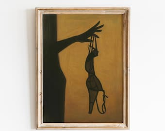 May include: Framed artwork featuring a silhouette of a hand holding a bra. The bra is dark, and the background is a warm, golden hue. The artwork is in a wooden frame, adding a touch of rustic charm to the piece.