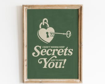 May include: A framed print with a green background and a heart-shaped lock with a key. The text reads "I DON'T WANNA KEEP Secrets You! JUST TO KEEP". The frame is a light brown color.