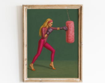 May include: A framed print depicting a woman in a pink leotard and gloves boxing a pink punching bag. The woman has blonde hair and is wearing a pink headband and orange heels. The background is a solid dark green.