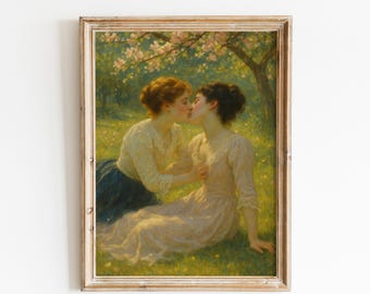 May include: A framed vintage painting depicts two women kissing in a sunlit meadow. One woman wears a cream-colored blouse and a dark blue skirt, while the other is in a light pink dress. The scene is set under a flowering tree.