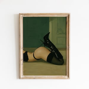 May include: A framed print of a woman in black lingerie and high-heeled boots. The artwork depicts a figure lying down, with one leg extended and the other bent. The background features a dark green wall and a light green floor.