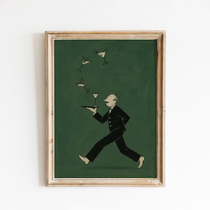 May include: A framed print featuring a cartoon illustration of a waiter in a black suit carrying a tray with a martini glass. Several martini glasses are floating in the air. The background is a dark green color.