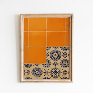 May include: Framed artwork featuring a vibrant orange tile design in the upper section and a patterned section below. The lower section showcases a tan background with navy blue floral motifs. The artwork is encased in a light-colored wooden frame.