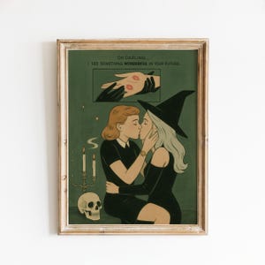 May include: Framed art print featuring two women kissing, one in a witch hat. The artwork has a green background with a skull, candles, and the text "OH DARLING... I SEE SOMETHING WONDERFUL IN YOUR FUTURE."
