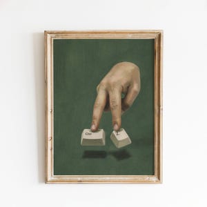 May include: A framed wall art print featuring a realistic painting of a hand pressing down on two computer keyboard keys, one labelled Ctrl and the other labelled Z, set against a solid dark green background within a light wood frame.