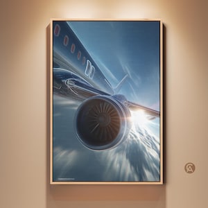 Könnte beinhalten: Ein gerahmtes Kunstwerk mit einem Düsenflugzeug im Flug, wobei der Fokus auf dem Triebwerk und der Tragfläche liegt. Das Bild ist vor einem hellen, sonnigen Himmel aufgenommen. Das Kunstwerk wird an einer neutralfarbenen Wand ausgestellt.