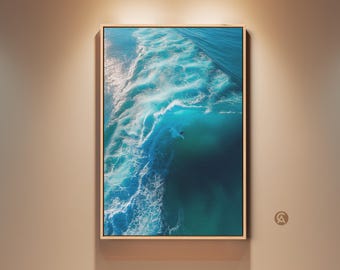 Könnte beinhalten: Gerahmter Druck einer türkisfarbenen Ozeanwelle mit weißen Schaumkronen. Das Kunstwerk zeigt einen Surfer, der die Welle reitet. Das Bild ist in einem hellen Holzrahmen gerahmt und hängt an einer beigen Wand.