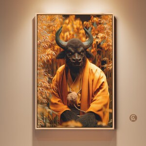 Può includere: Opera d'arte incorniciata raffigurante una creatura simile a un toro in una veste arancione, sullo sfondo di un fogliame autunnale. La creatura ha una pelliccia scura, grandi corna e un'espressione serena. L'opera è esposta in una cornice di legno chiaro.