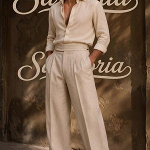 K&ouml;nnte beinhalten: Ein beiges, lang&auml;rmeliges Hemd mit Knopfleiste und Kragen sowie eine passende, hoch taillierte Hose mit weitem Bein und seitlichem Schnallendetail. Das Outfit wird mit dunkelbraunen Lederschuhen und dunkel get&ouml;nten Sonnenbrillen kombiniert.