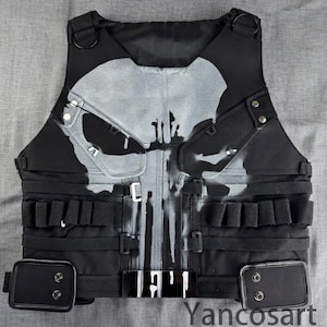 Puede incluir: Chaleco táctico negro con un gran diseño de calavera gris desgastado. El chaleco tiene múltiples bolsillos, correas ajustables y un cierre de hebilla. El texto "Yancosart" es visible en la parte inferior derecha.