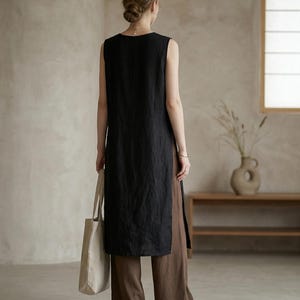 May include: A white ceramic mug with a black handle and the text "But First, Coffee" in a bold, black font. The mug is set against a blurred background, suggesting a cozy setting.