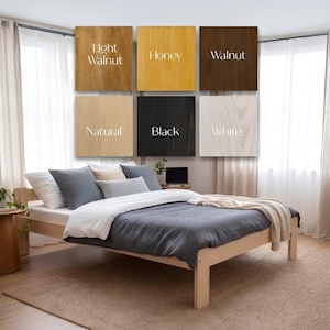 Op de afbeelding: Een licht houten bedframe met een grijze dekbedovertrek en kussens. De afbeelding toont kleurstalen met de labels "Light Walnut", "Honey", "Walnut", "Natural", "Black" en "White". Er ligt een beige tapijt op de vloer.