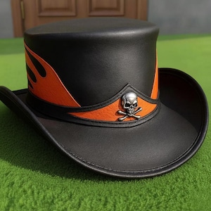 May include: Black leather top hat with orange flame detailing and a silver skull and crossbones emblem. The hat has a cylindrical crown and a curved brim. Ideal for themed events or cosplay.